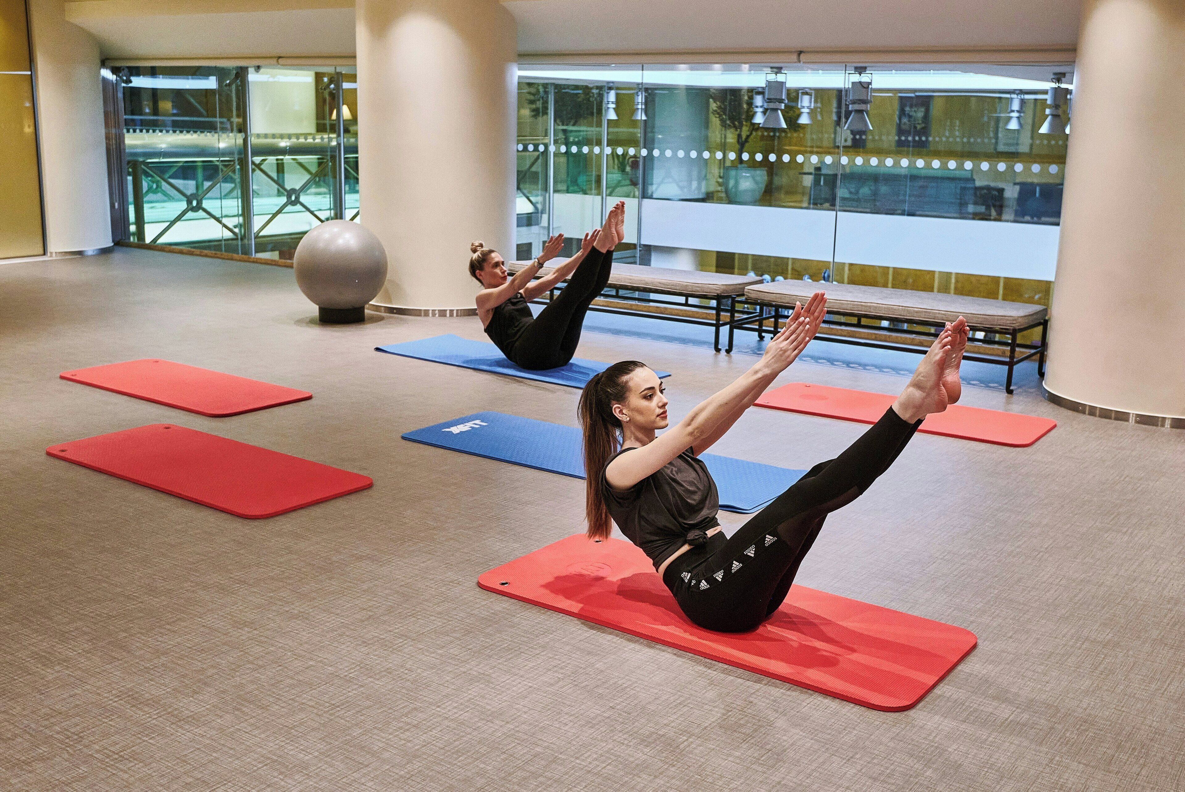 Amplio espacio interior con colchonetas y bancos de ejercicio, probablemente un gimnasio o estudio de yoga.
