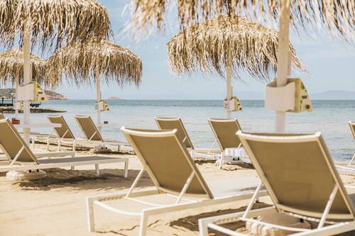 Camastros, sombrillas, toallas de playa y bar en la playa
