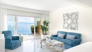 Et moderne hotelværelse med stor balkon, blå sofa, glasbord og dekorativ vægdekoration.