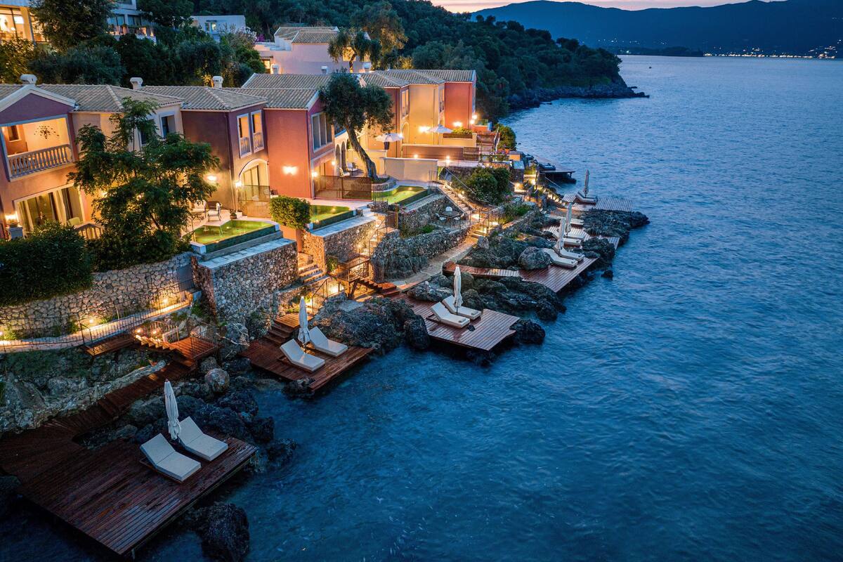 A coastal hotel with multiple buildings, a rocky shoreline, and a view of the sea.
