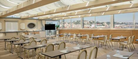 A conference room with a city view, large windows, and a modern ceiling design.