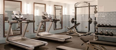 A gym with treadmills, a weight bench, and a squat rack.