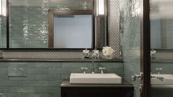 A modern bathroom with a large mirror, a sink, and a toilet.