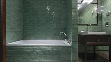 A bathroom with a rectangular bathtub, a sink, and a mirror.