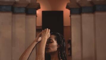 A person in a pool with arched ceilings and wall-mounted lights.
