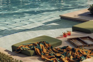 A poolside area with a lounge chair, a blanket, and a board game. - One&Only Royal Mirage (Dubai)
