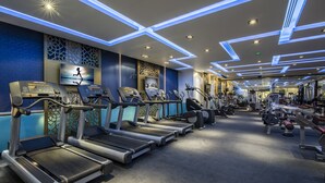 A modern gym with treadmills, exercise bikes, and weight machines. - Metropolitan Al Mafraq Hotel (Abu Dhabi)