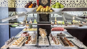 A buffet with various desserts and fruits. - Metropolitan Al Mafraq Hotel (Abu Dhabi)