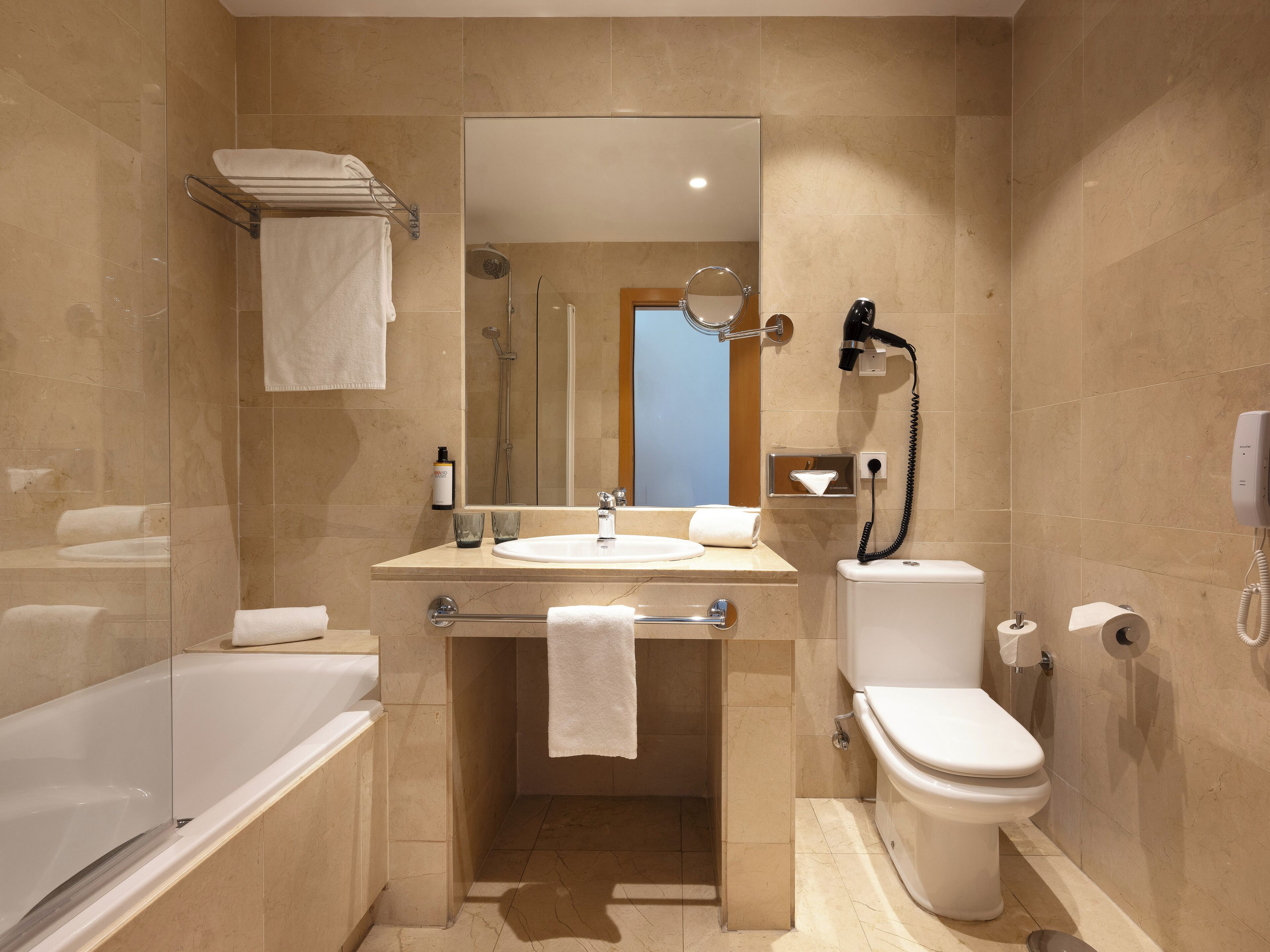 A modern bathroom with a bathtub, toilet, and sink.