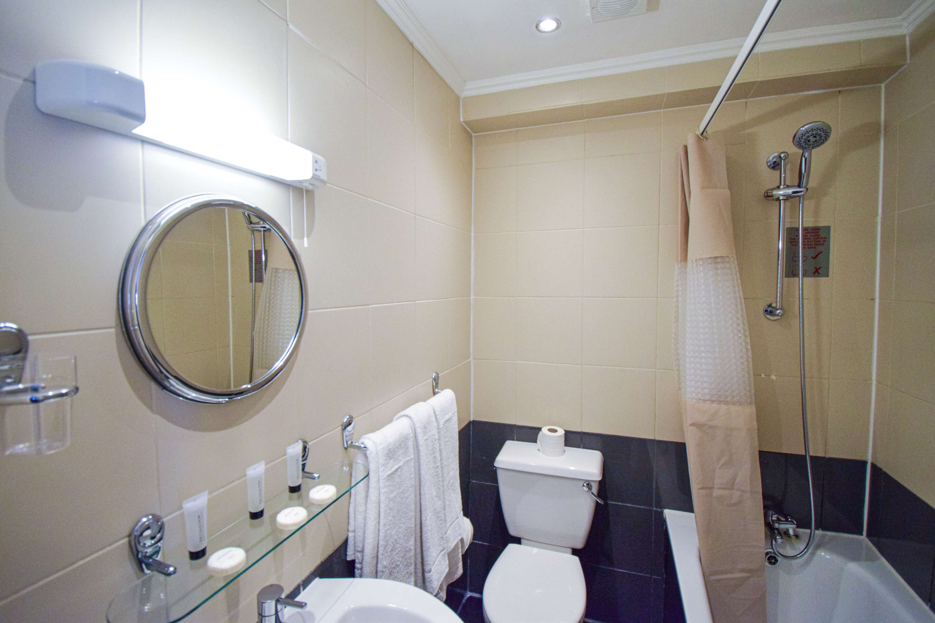 A bathroom with a toilet, sink, and shower.