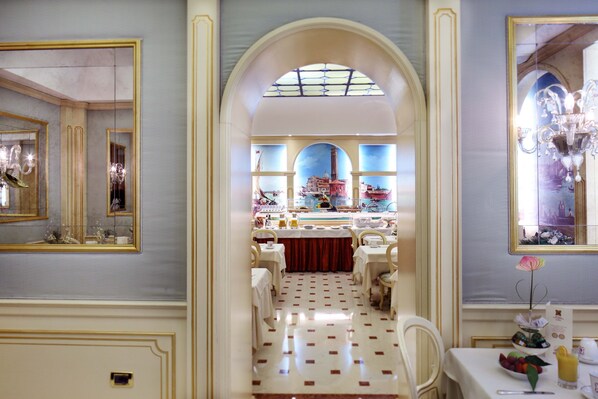 A dining area with a central archway leading to a view of a cityscape. Tables are set with white tablecloths and chairs. - Colombina Hotel (Venice)