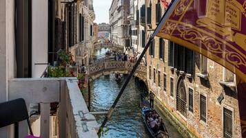 Un canale con una gondola, edifici con balconi e una bandiera.