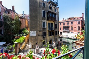 Un edificio histórico con balcón que da a un canal, con un letrero que indica un restaurante.