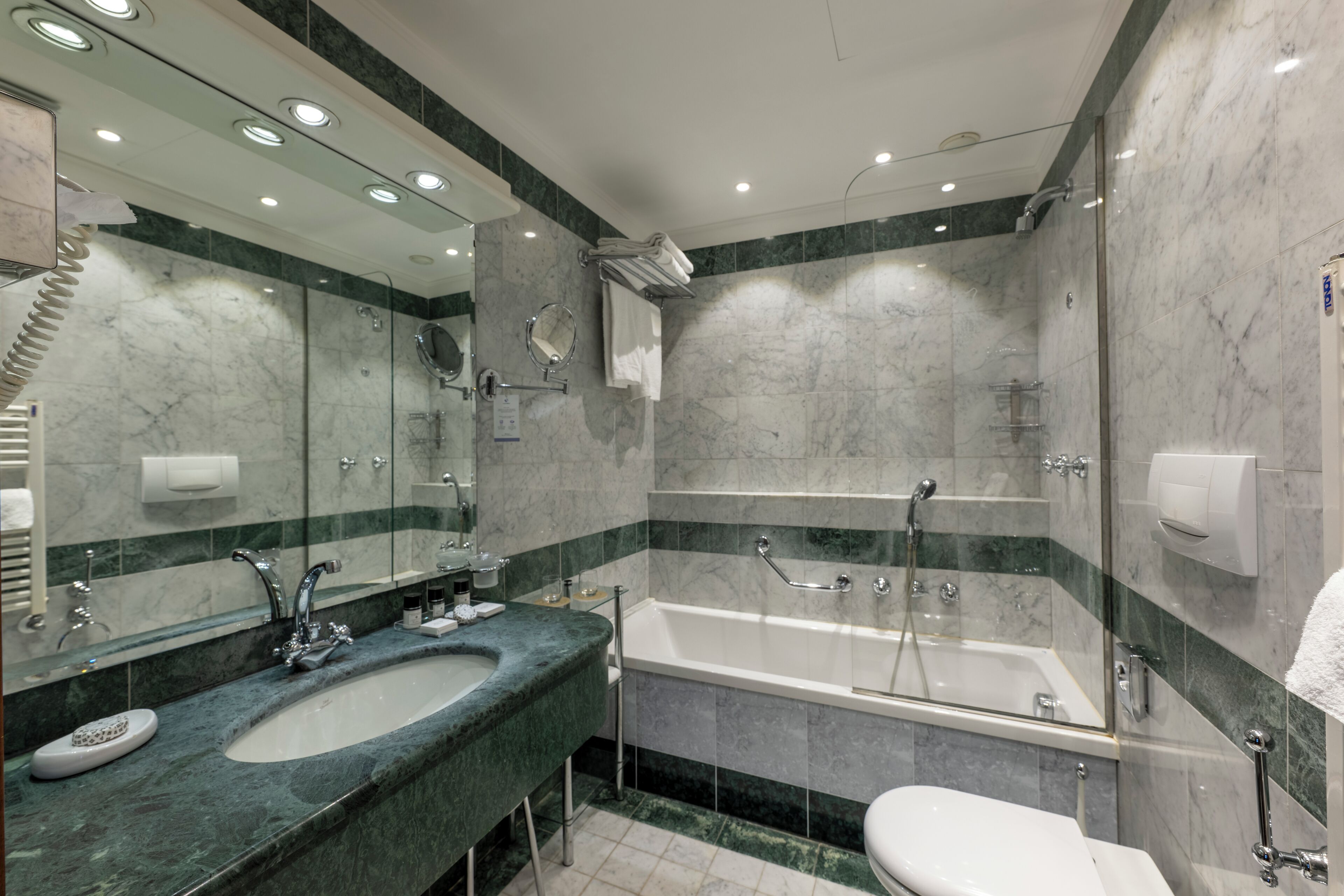 Un baño moderno con un lavamanos grande, espejo y bañera.