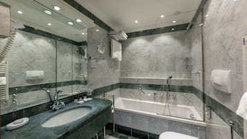 Un baño moderno con un lavamanos grande, espejo y bañera.