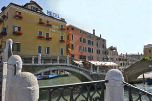 A hotel with a sign that reads "HOTEL A TRIECCINO" across the facade. - Hotel Arlecchino (Venice)