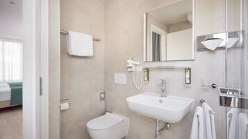 A modern bathroom with a bidet, sink, and mirror.