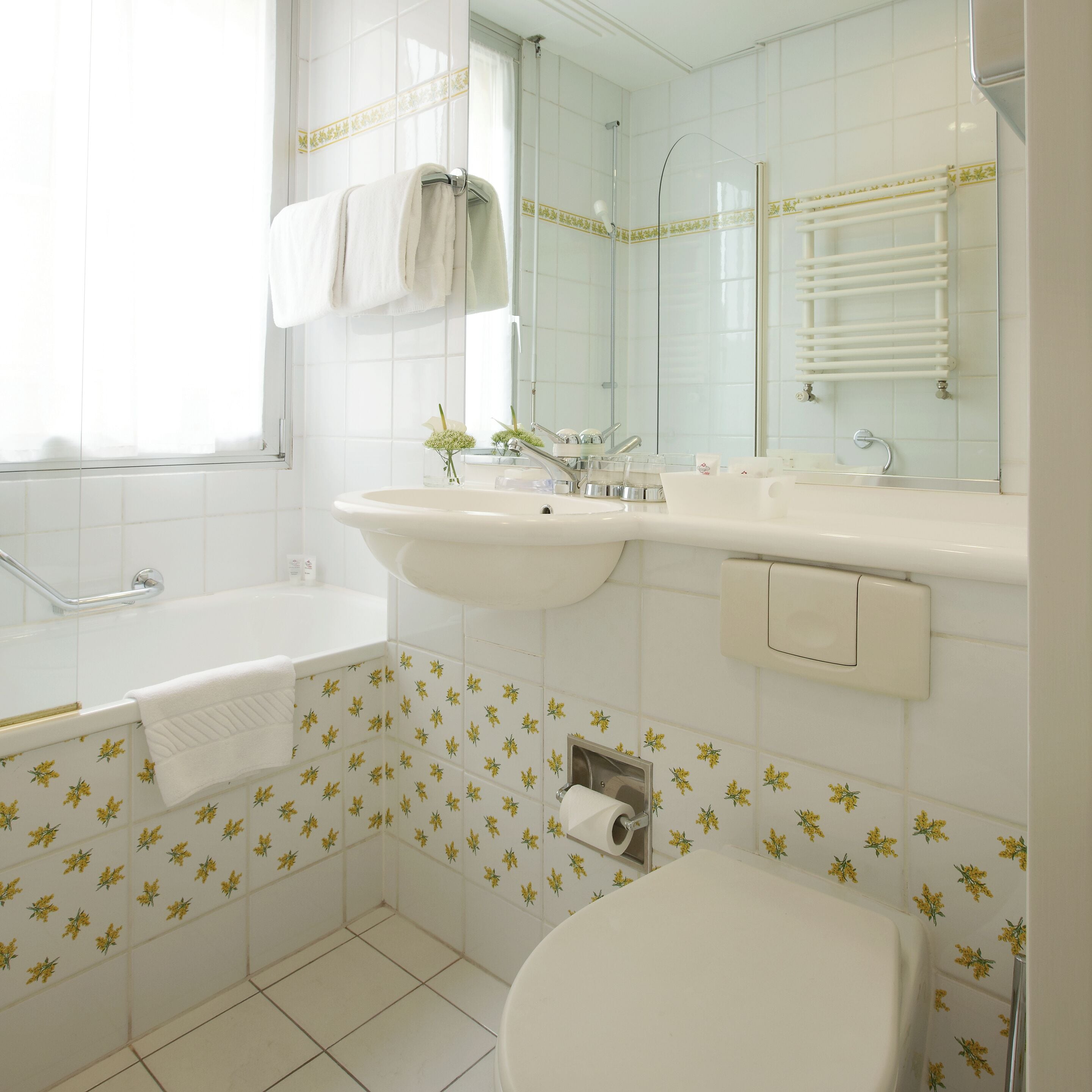 A bathroom with a bathtub, sink, toilet, and a mirror.