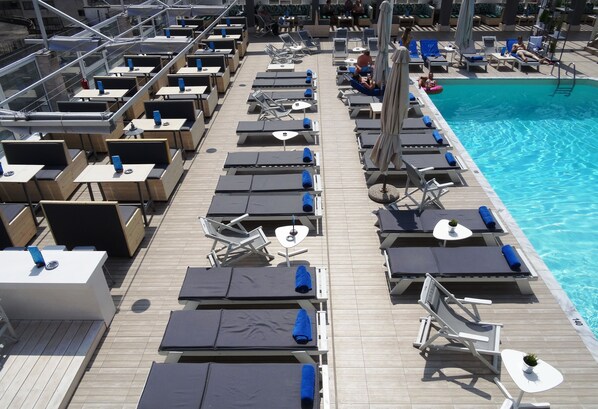 Piscine extérieure en saison, parasols, chaises longues