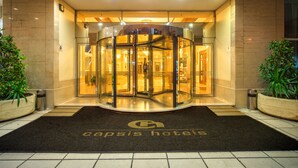 A hotel entrance with a revolving door, a reception desk, and a doormat with the hotel's name. - Capsis Hotel Thessaloniki (Thessaloniki)