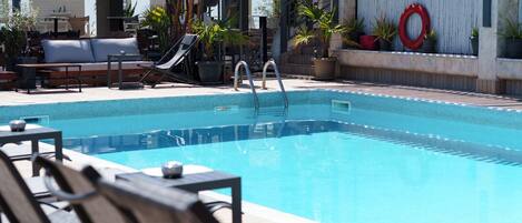Una piscina al aire libre de temporada, sombrillas