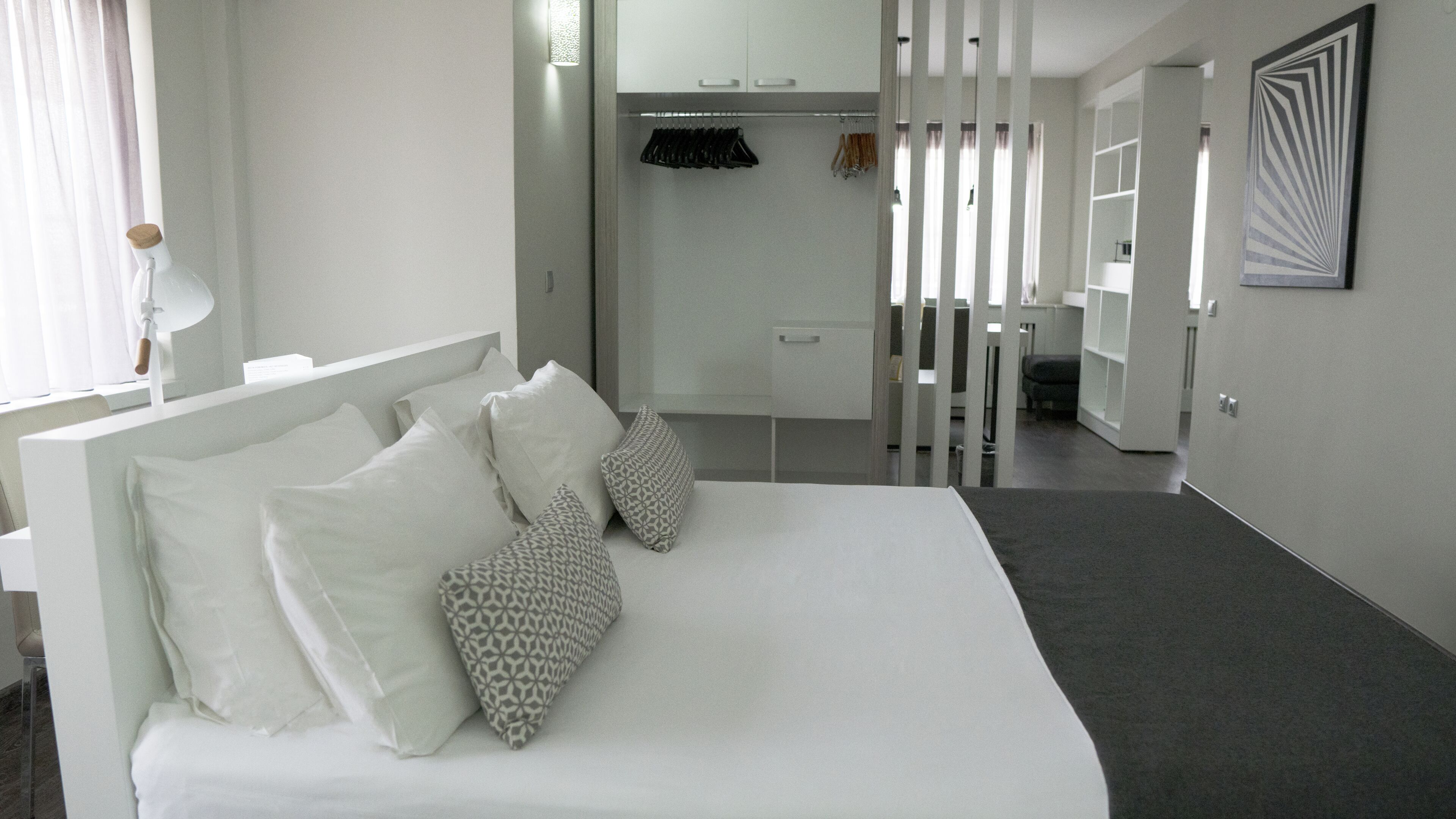 Un dormitorio moderno con una cama grande, un armario y un espejo.