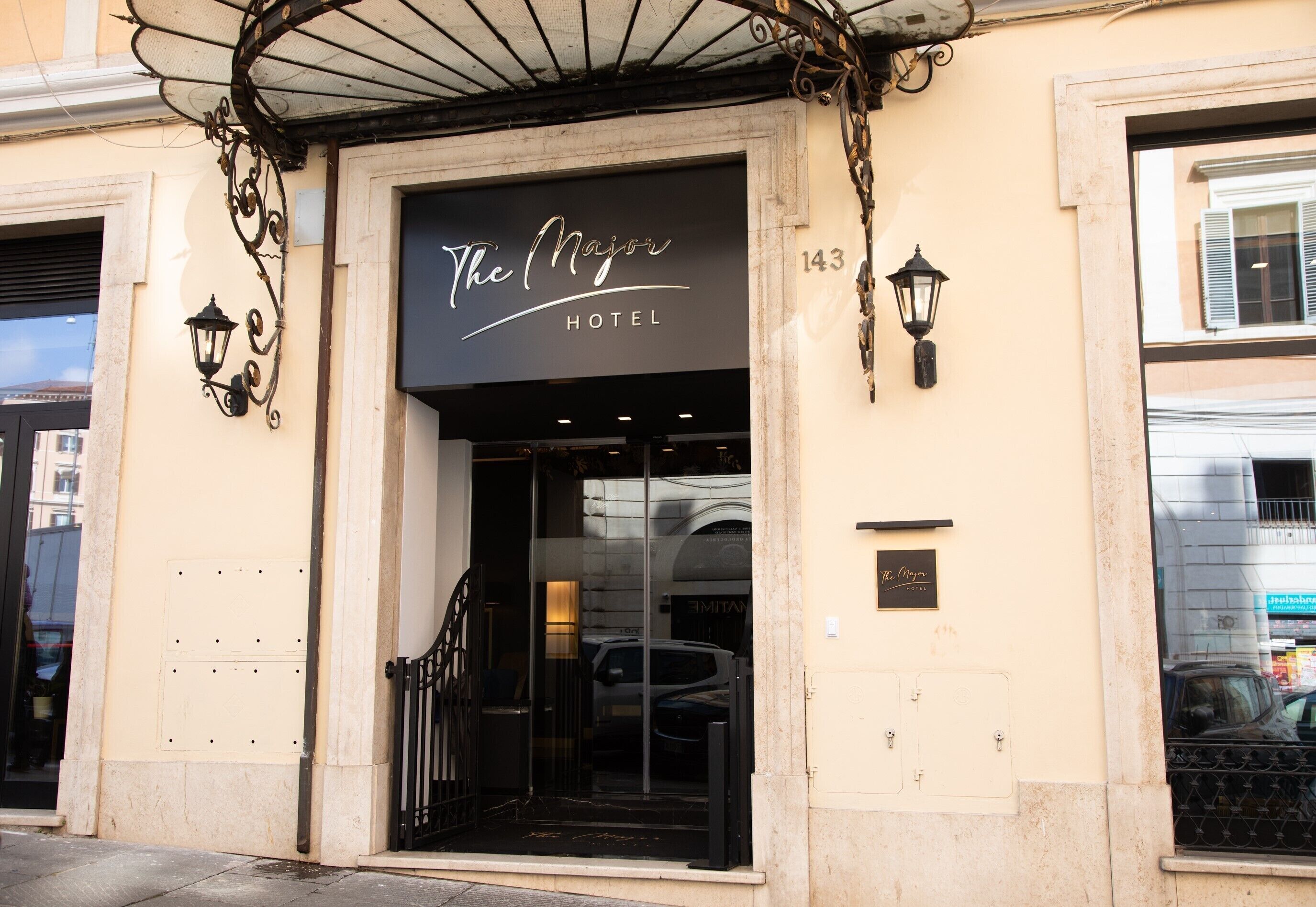 The Majors Hotel entrance with a black sign, glass doors, and a metal gate.