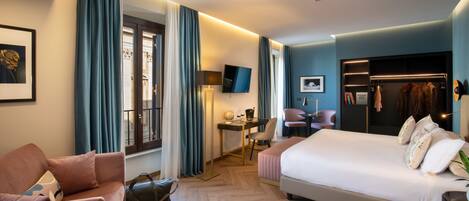 Una habitación de hotel con una cama grande, un escritorio, una silla, un sofá y un armario.
