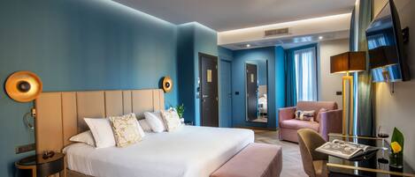 Une chambre d’hôtel moderne équipée d’un grand lit, d’un bureau, d’une chaise et d’un téléviseur.