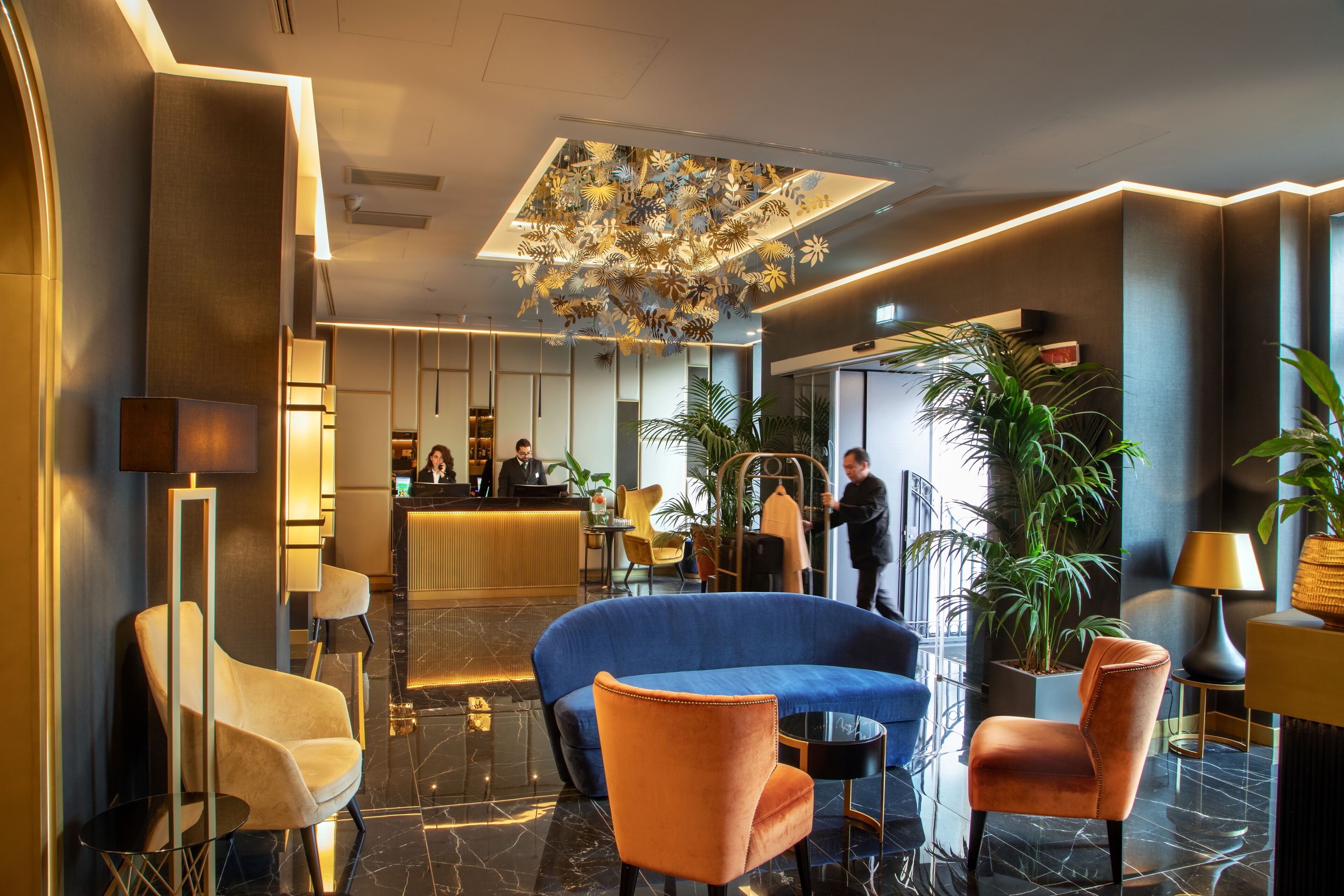 A modern lobby with a reception desk, seating area, and decorative ceiling.