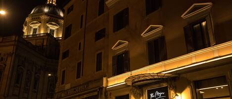 A hotel with a sign reading "The Majestic Hotel" and a dome structure in the background.