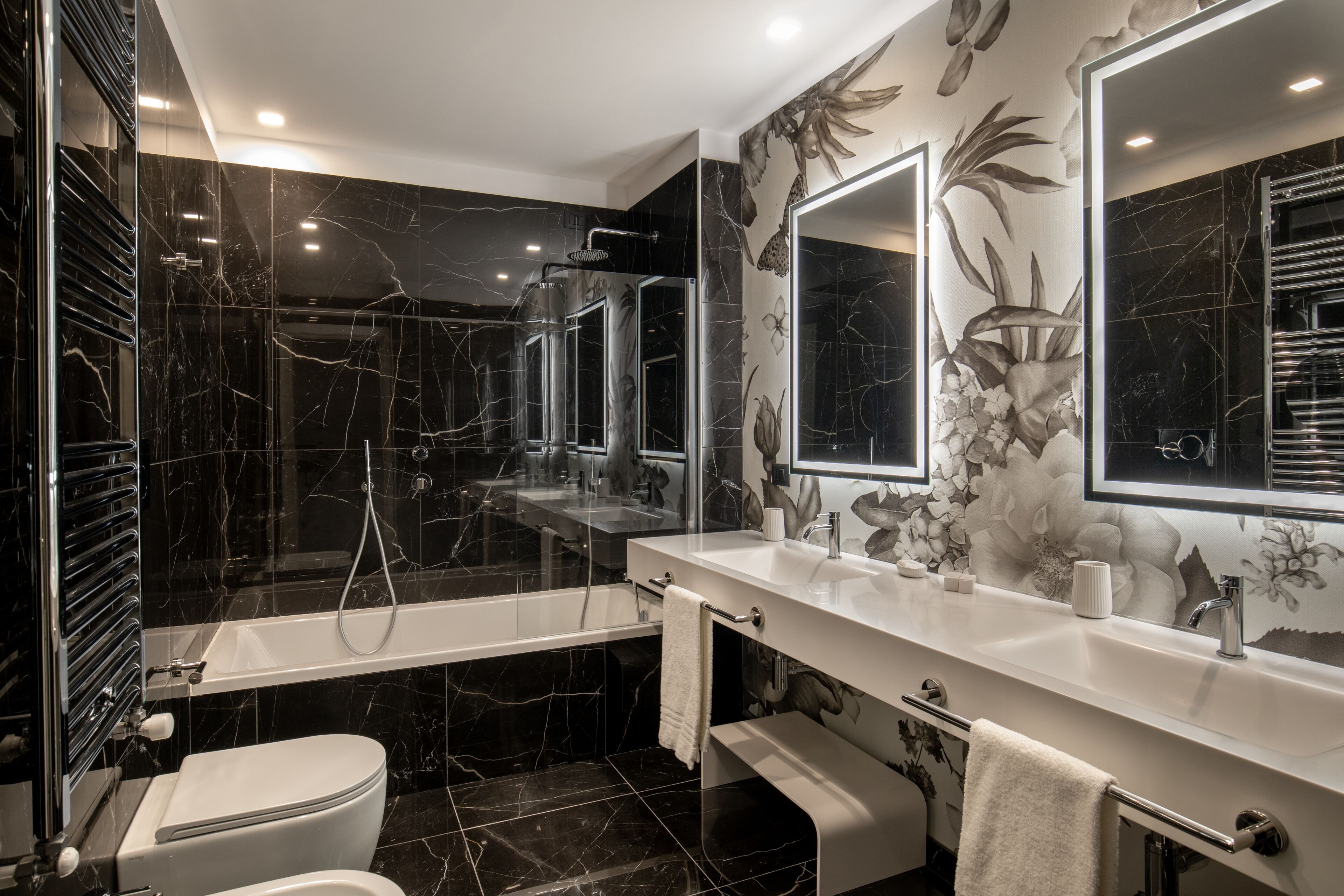 Et moderne badeværelse med badekar, toilet og vaskebord med spejl.