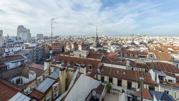 Un paisaje urbano con edificios muy juntos, algunos con antenas y parabólicas visibles, y un cielo despejado.