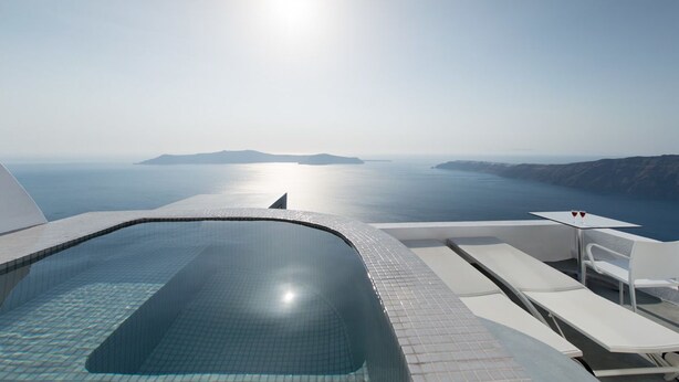 A modern infinity pool with a clear view of the sea and distant islands. - Regina Mare Adults Only (Santorini)