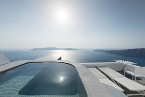 A modern infinity pool with a clear view of the sea and distant islands. - Regina Mare Adults Only (Santorini)