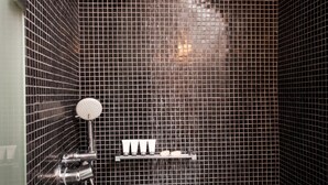 A shower with a handheld showerhead and a wall-mounted faucet. - Regina Mare Adults Only (Santorini)