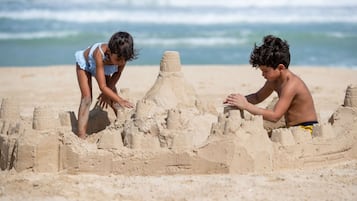 Children build sandcastles on the beach, where guests can enjoy relaxation and outdoor activities.