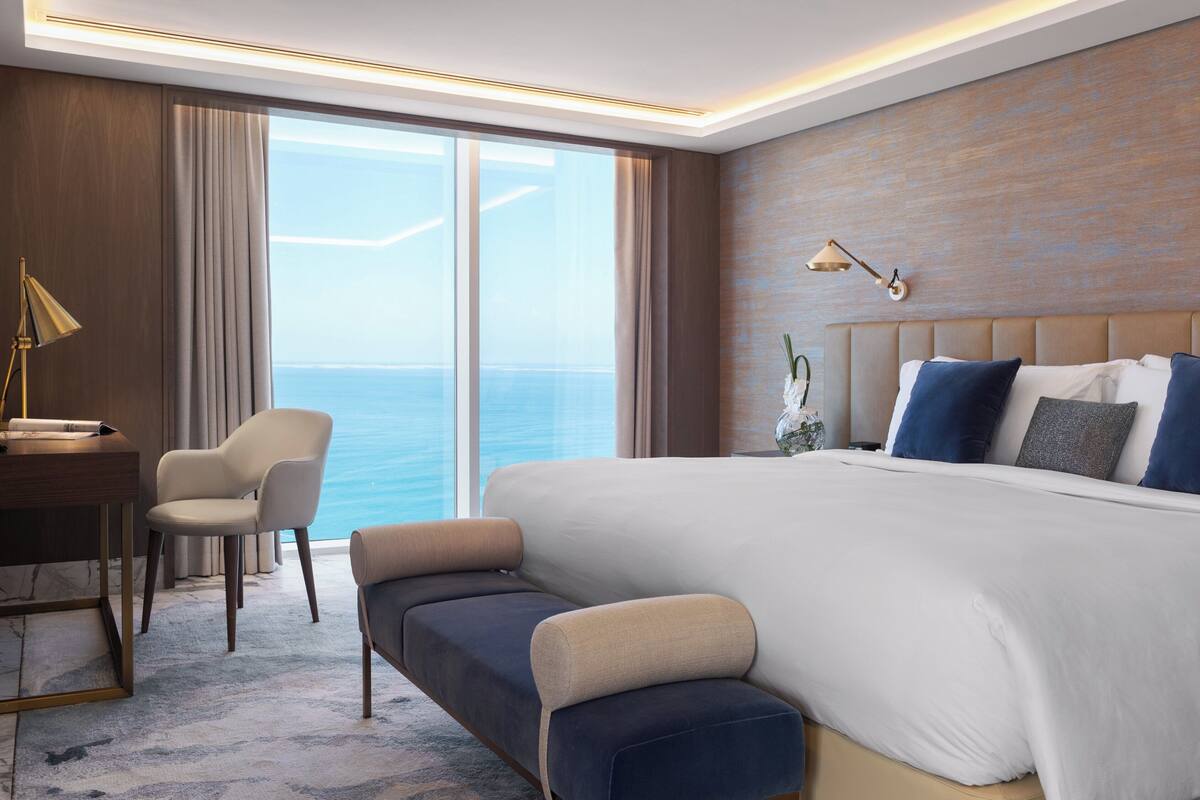 Una habitación de hotel moderna con una cama grande, un escritorio y una silla.