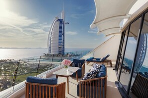 En balkon med udsigt til Burj Al Arab, møbleret med sofaer og et bord.