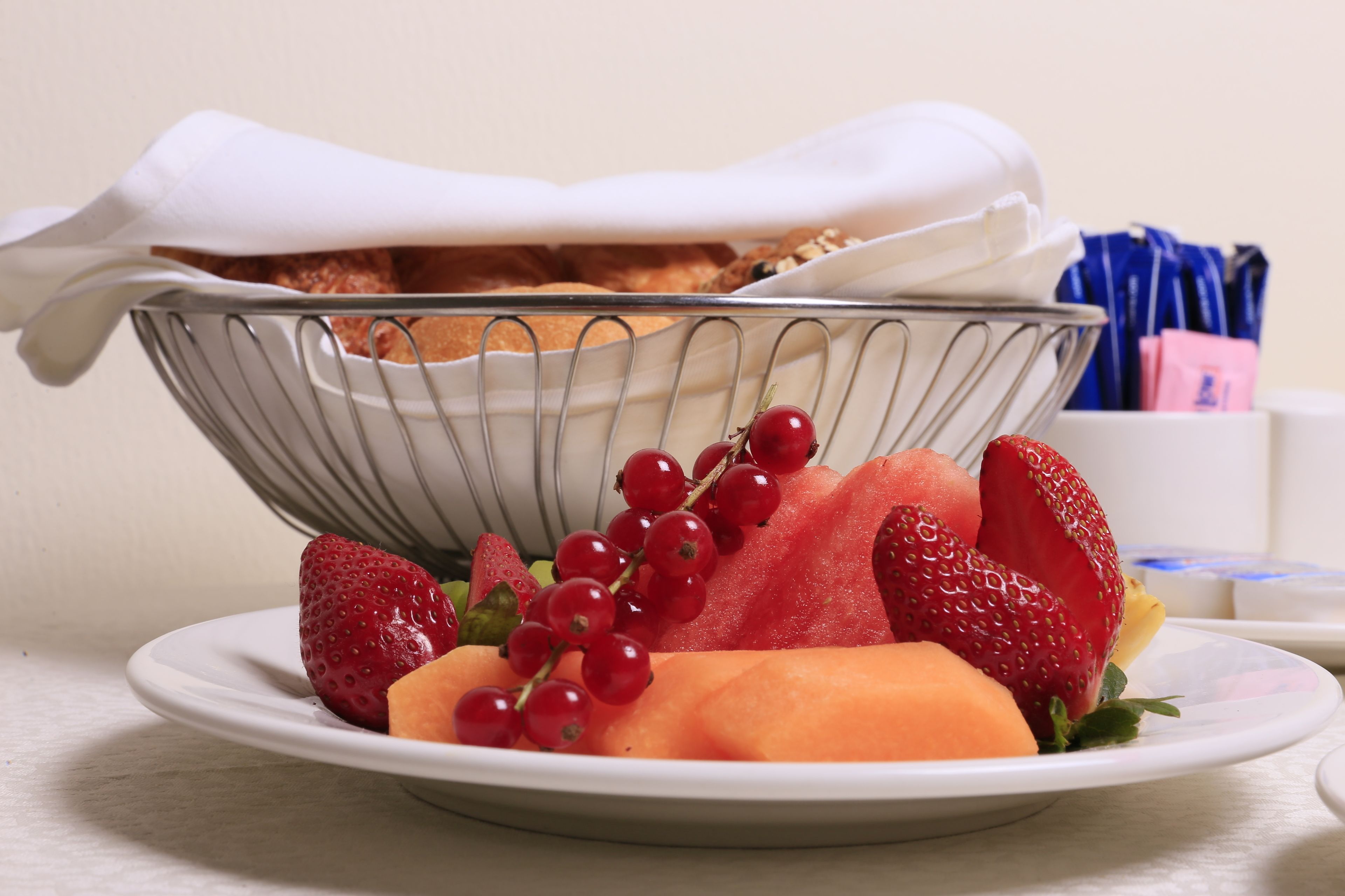 Un plato con fresas, sandía y grosellas rojas.