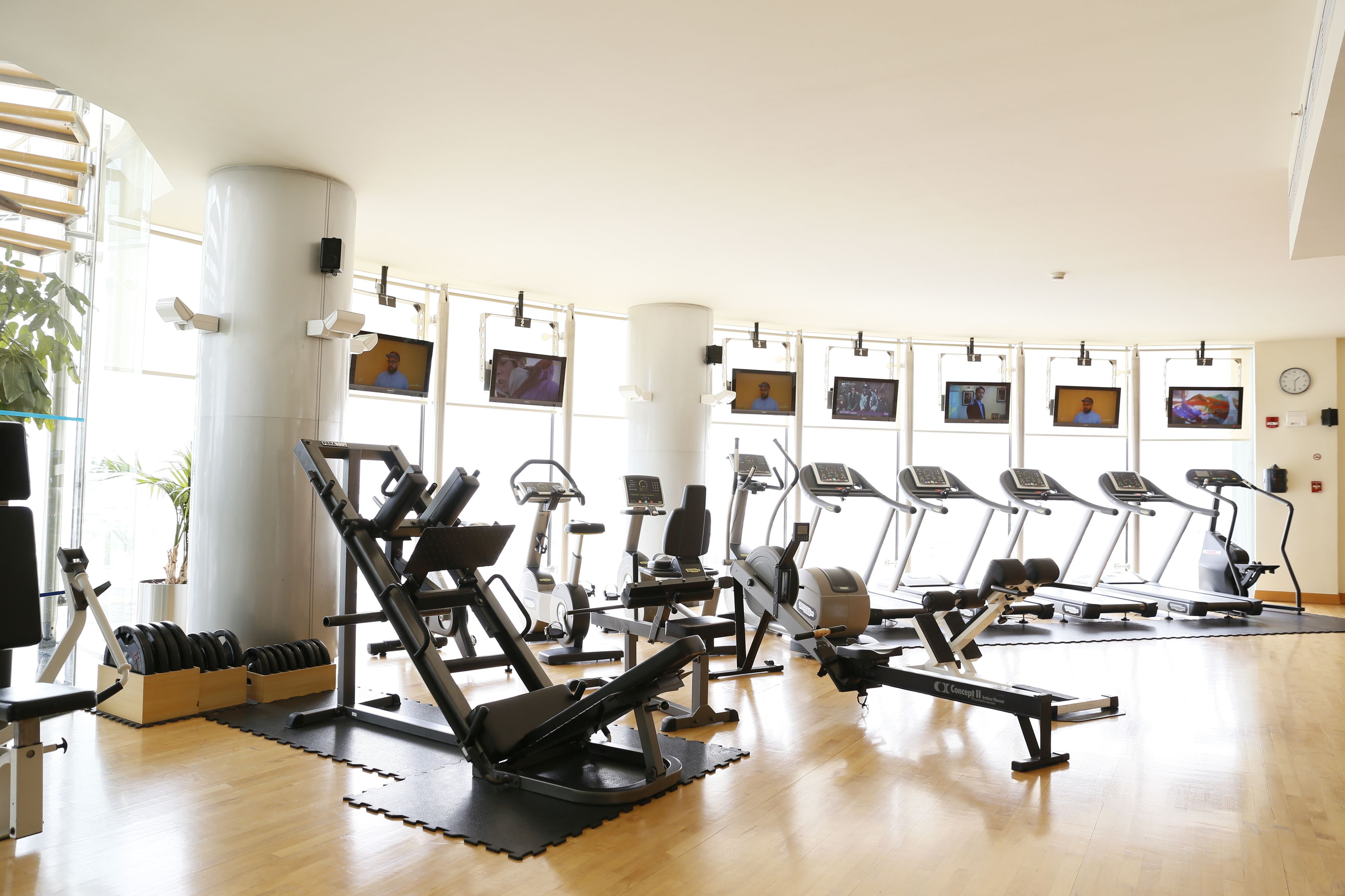 A gym with cardio machines, weightlifting equipment, and mirrors.