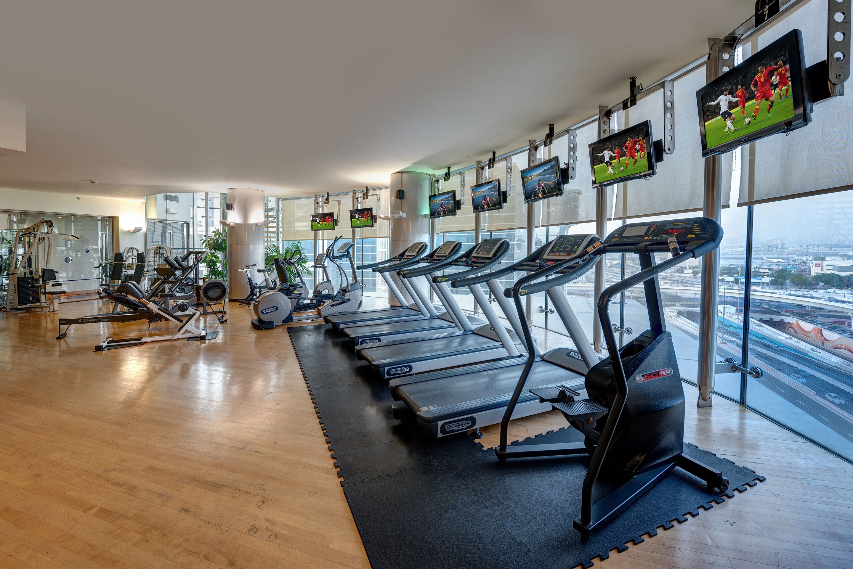 A gym with treadmills, exercise bikes, and rowing machines.
