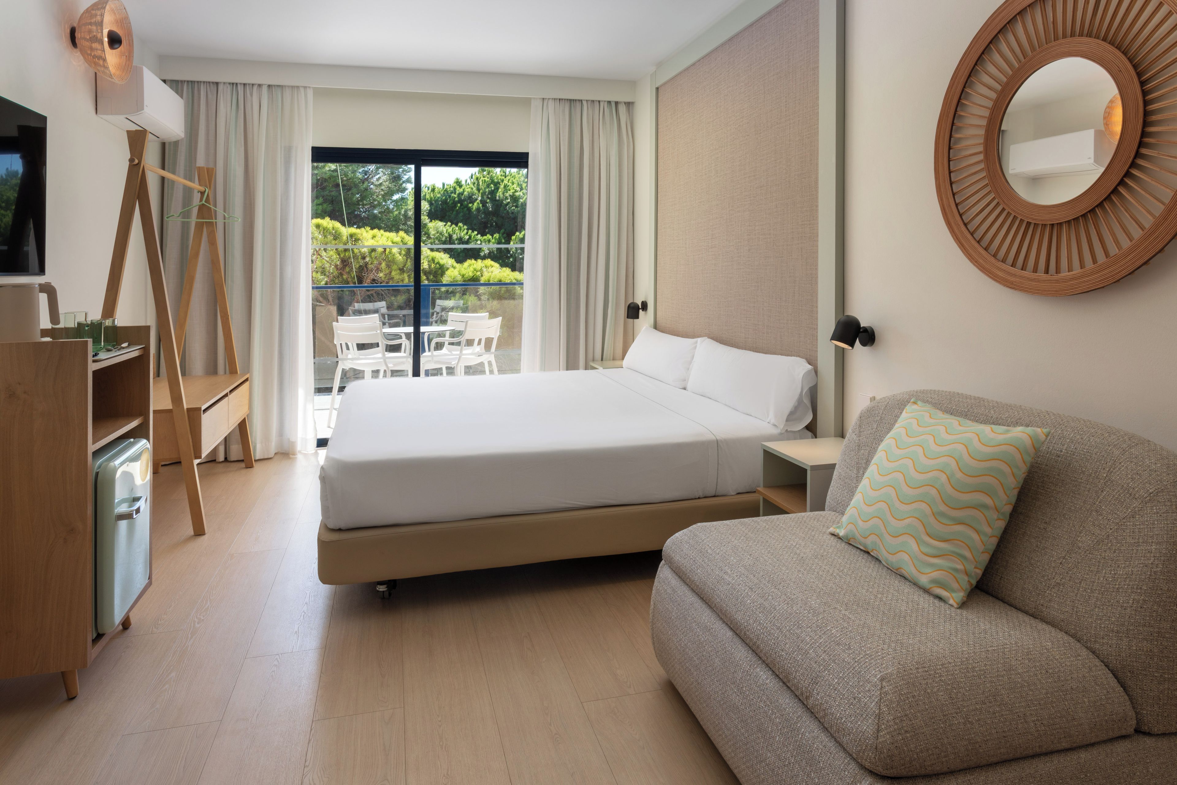 Una habitación de hotel con cama, sofá, escritorio y televisión.