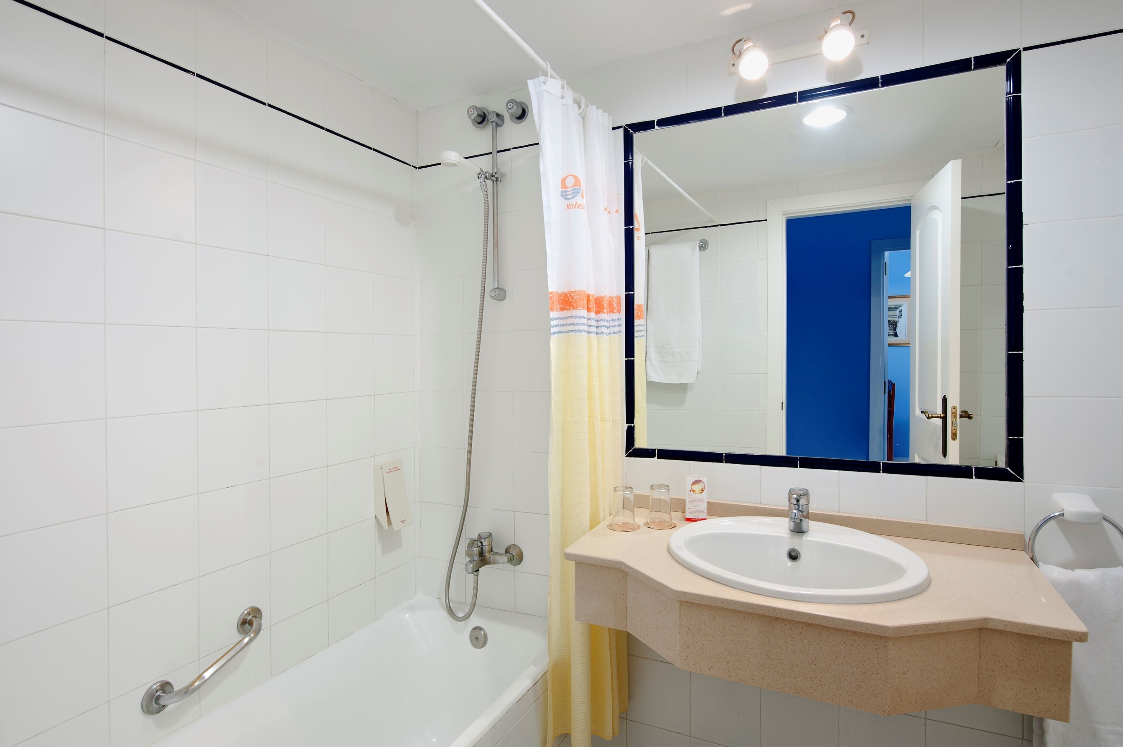 A modern bathroom with a bathtub, shower, and sink.