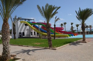 Parque acuático con toboganes y palmeras.