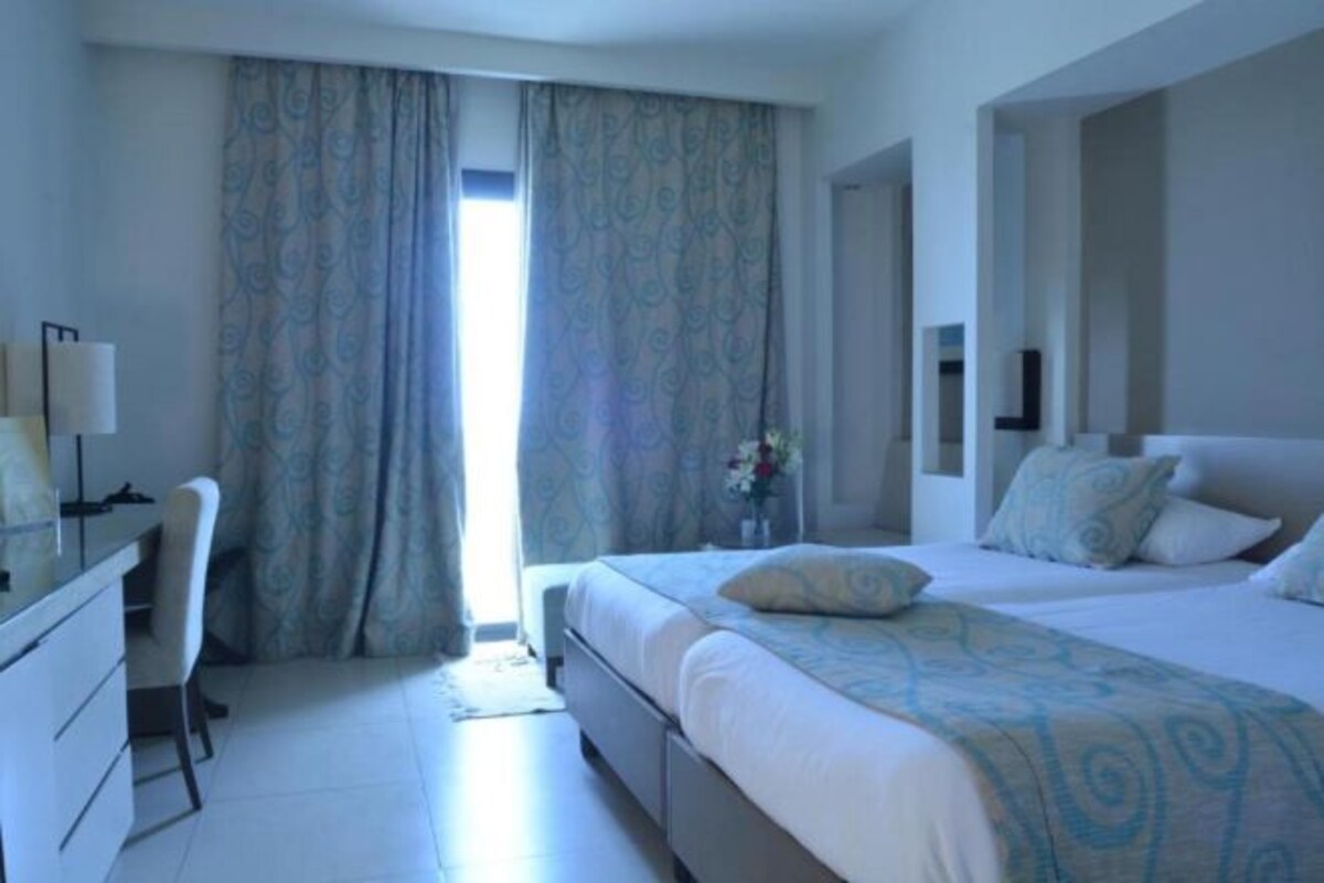 A hotel room with a bed, a desk, and a chair.