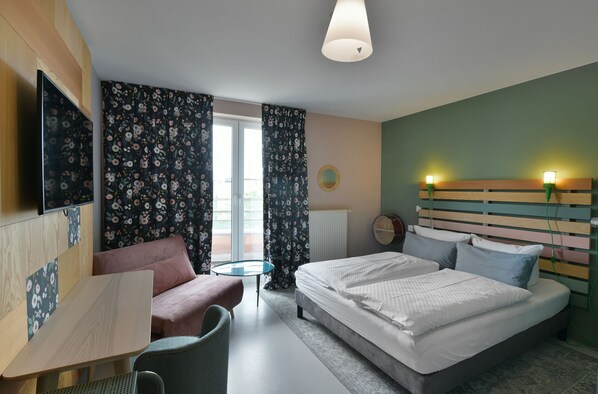 A modern hotel room with a bed, a desk, a chair, and a view of the outdoors. - Hotel BIRGIT Berlin Mitte (Berlin)
