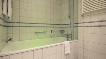 Baño con bañera, ducha y baranda.
