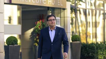 Ein Mann in einem dunklen Anzug geht zum Eingang des Mercure Hotels.