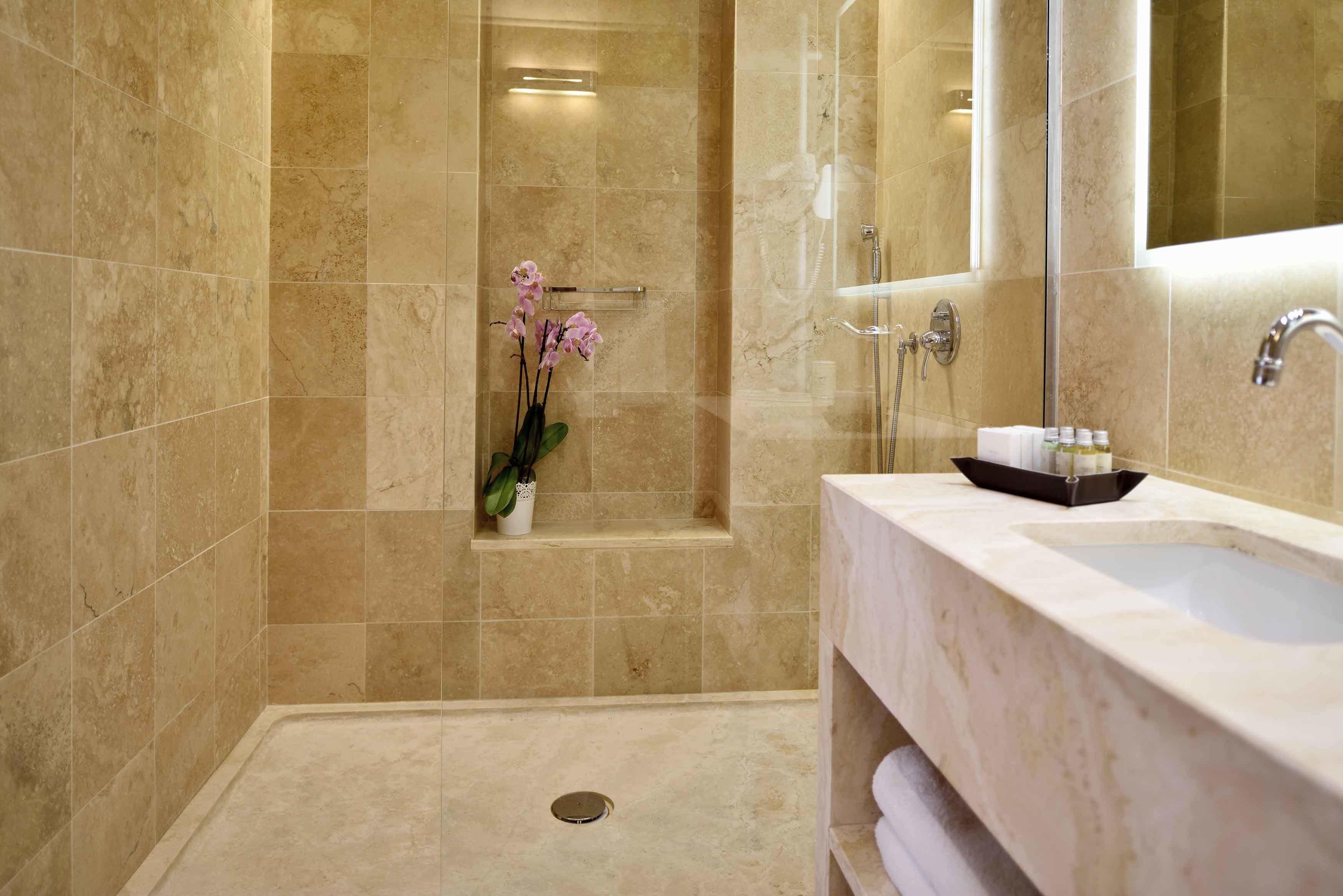 A modern bathroom with a walk-in shower, a large mirror, and a vanity with a sink.